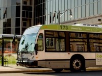 A bus sitting in front of a glass building and bus terminal 
