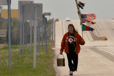 Josephine Mandamin carrying a pail of water