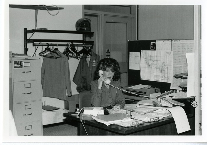 A woman talking on the phone while looking at the camera in an office