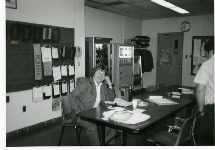 A man sitting facing the camera and smiling at a desk in an office