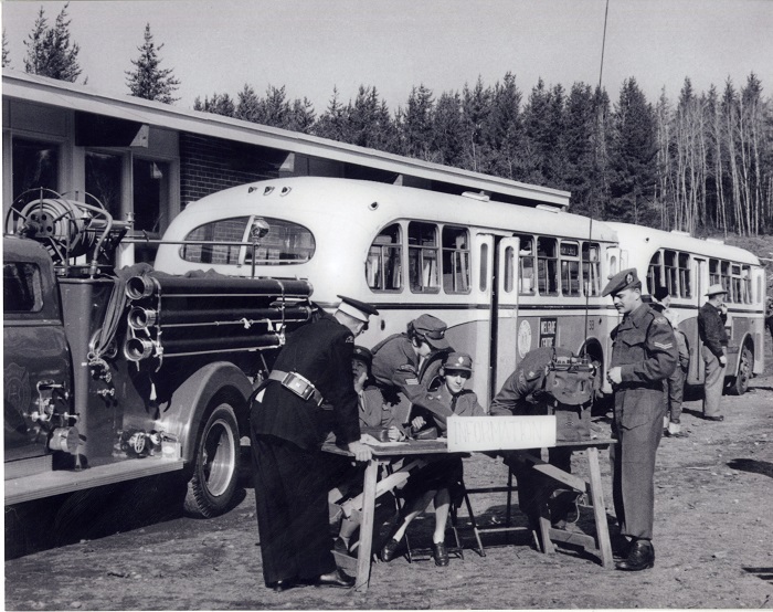 a group of people in military uniform at a table that says "Information" on it. 