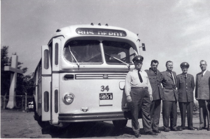 six men posing for a photo in front of a #34 bus.