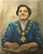 Mayor Catherin Seppala sitting wearing blue robes and necklace 