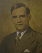 Mayor Charles Cox wears a brown suit and gold tie