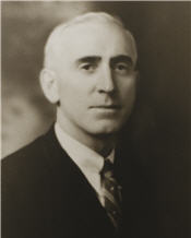Mayor Anderson sitting for a black and white photo wearing a suit and tie 