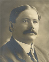 Mayor James Murphy sitting for a black and white photo and wearing a suit