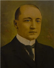 Mayor James Mooney sits wearing a black suit 