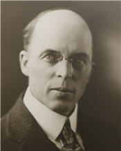 Mayor N. B. Darrell sitting for his photogrpah weaing a suit with small armless glasses