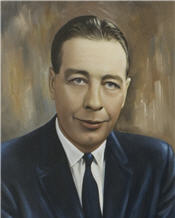 Mayor Norman wilson sits wearing a blue suit and blue tie 