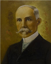 Mayor Ray sits wearing a suit and has a large white moustache