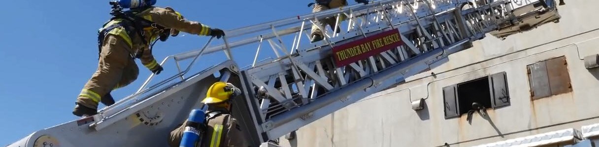 firefighters on ladder of aerial truck