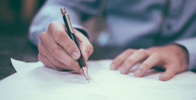 Pen signing a piece of paper