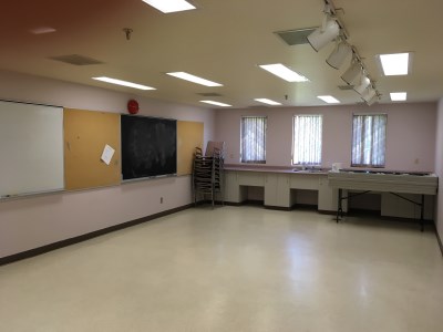 inside of the 55 Plus Centre Craft Room 2 with a whiteboard and chalkboard