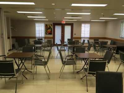 inside of the 55 Plus Centre Meeting Room with several desks and chairs