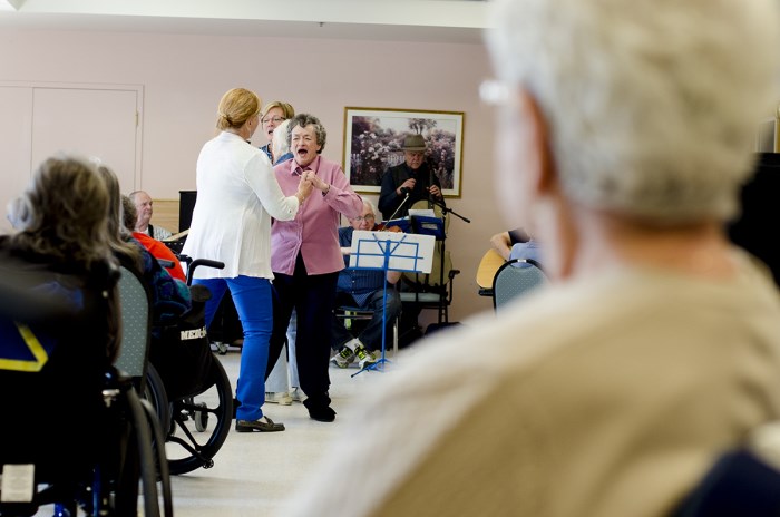 elderly people dancing and playing instruments