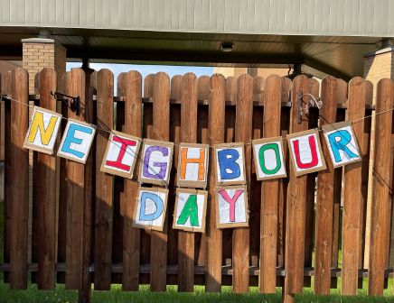 Neighbour Day sign on a fence