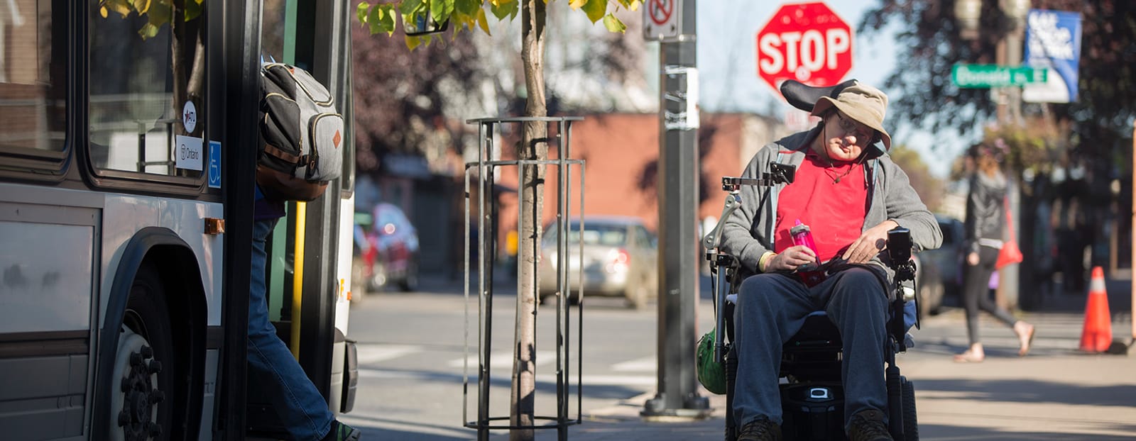 man in a wheelchair next to a city bus