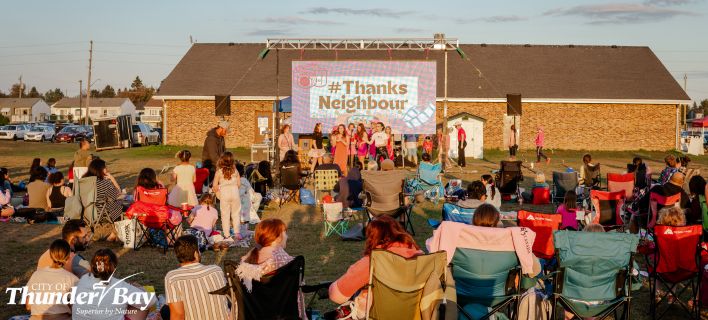 Neighbour Day image of people sitting to watch an outdoor movie