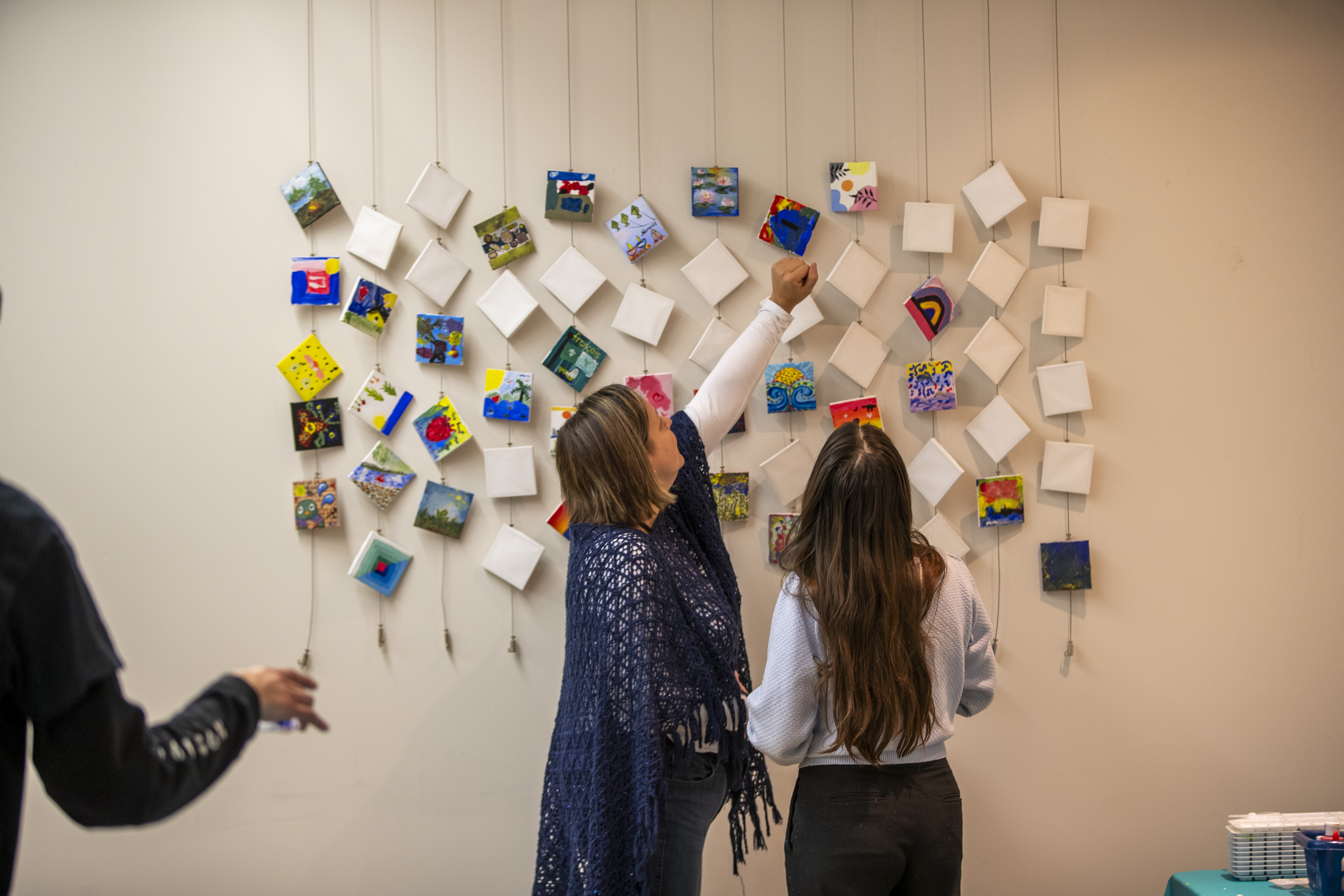 A photo of the art project with participants pointing at the art
