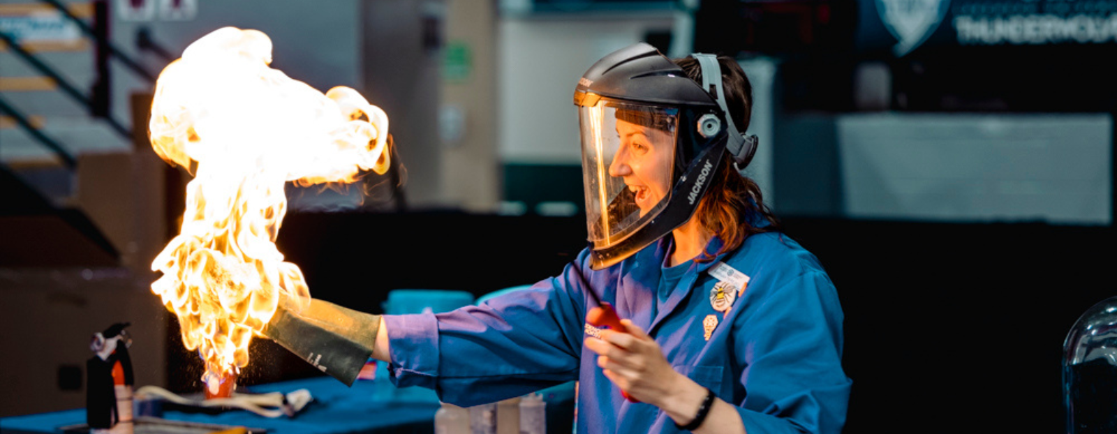 Young person wearing protective equipment holding flames