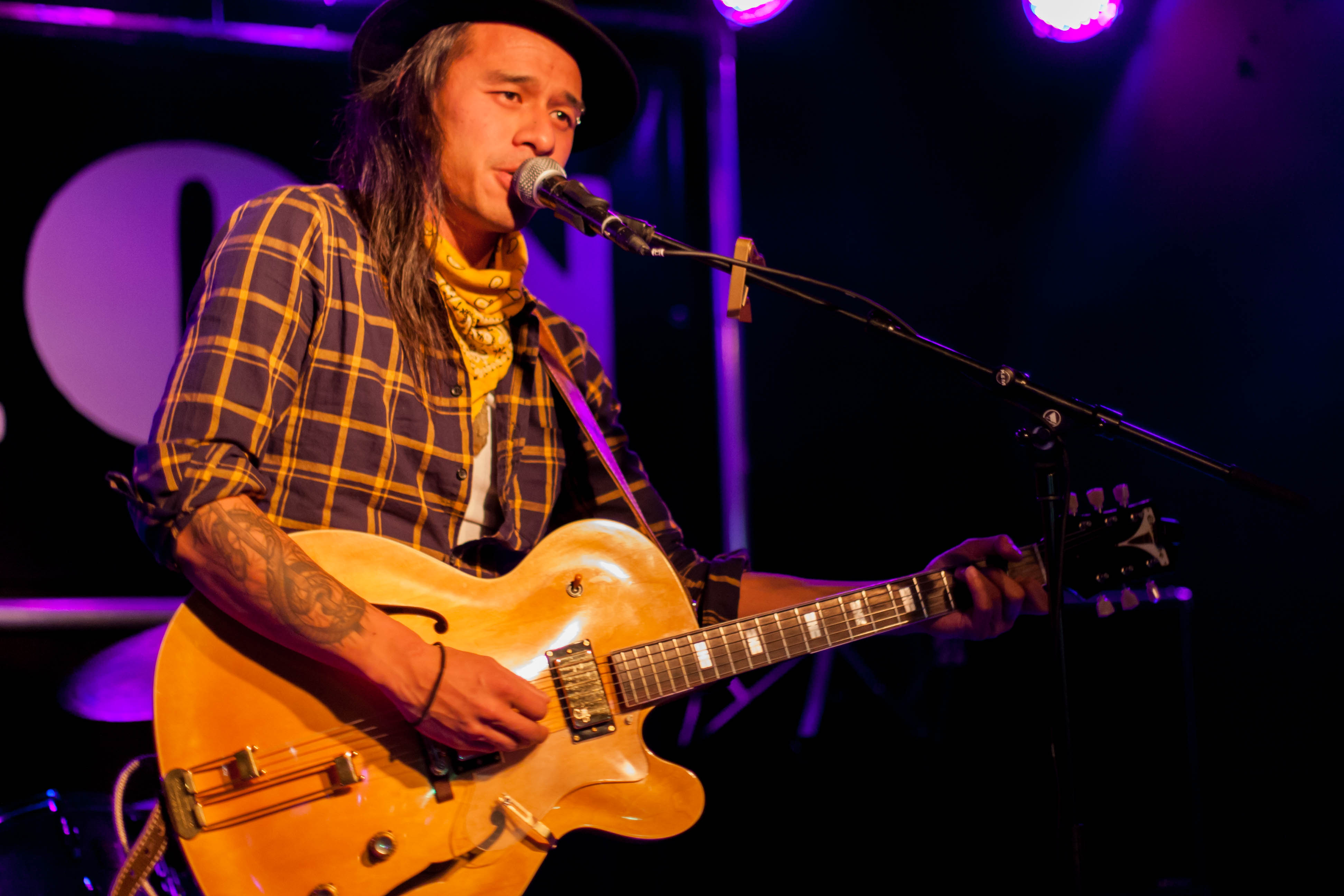 Musician Tennyson King playing the guitar and singing on stage