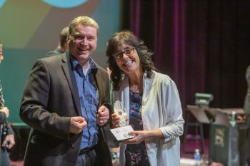 man presenting award to woman on stage