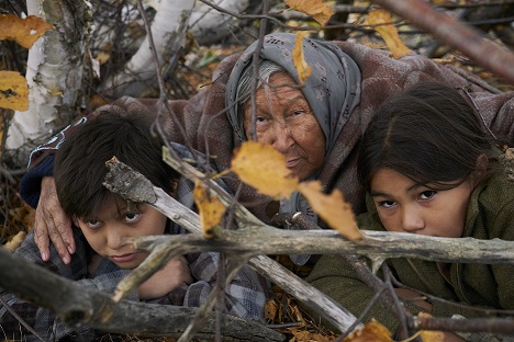 Still from the Film Indian Horse - Naomi crouches in bushes with grandsons