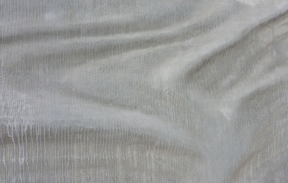 Embedded history sculpture near Baggage Building with a wave-like texture