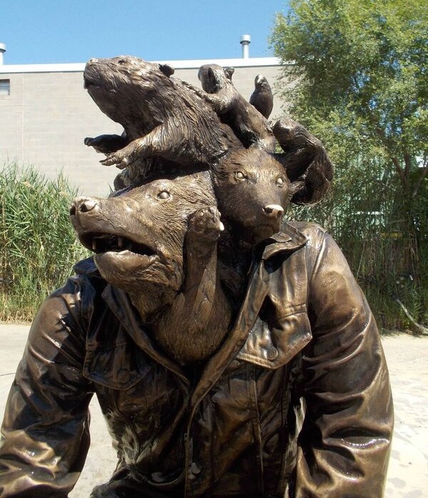 sculpture of various wild animals coming out of the head of a jacket 
