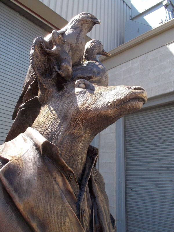 sculpture of various wild animals coming out of the head of a jacket 