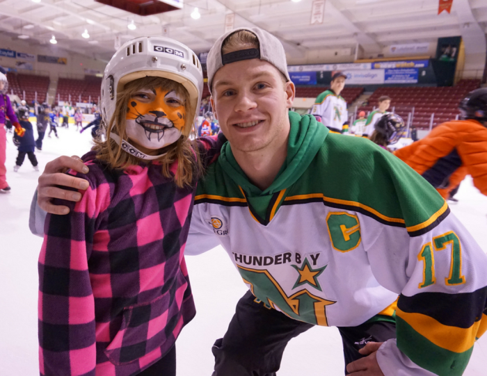 Young skater and local hockey player pose for a picture