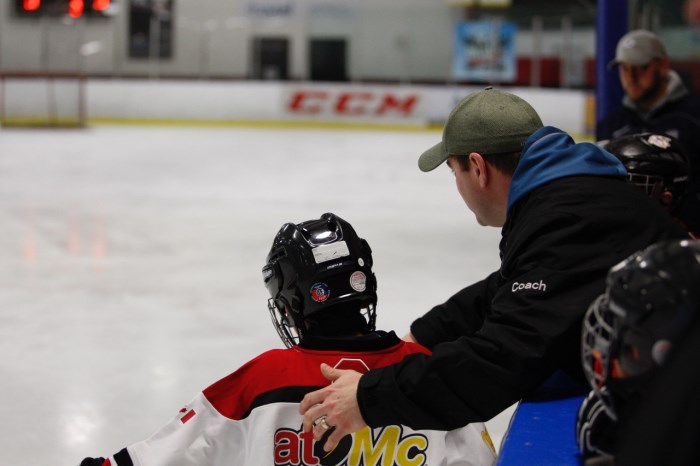 Coach directing hockey player on the ice