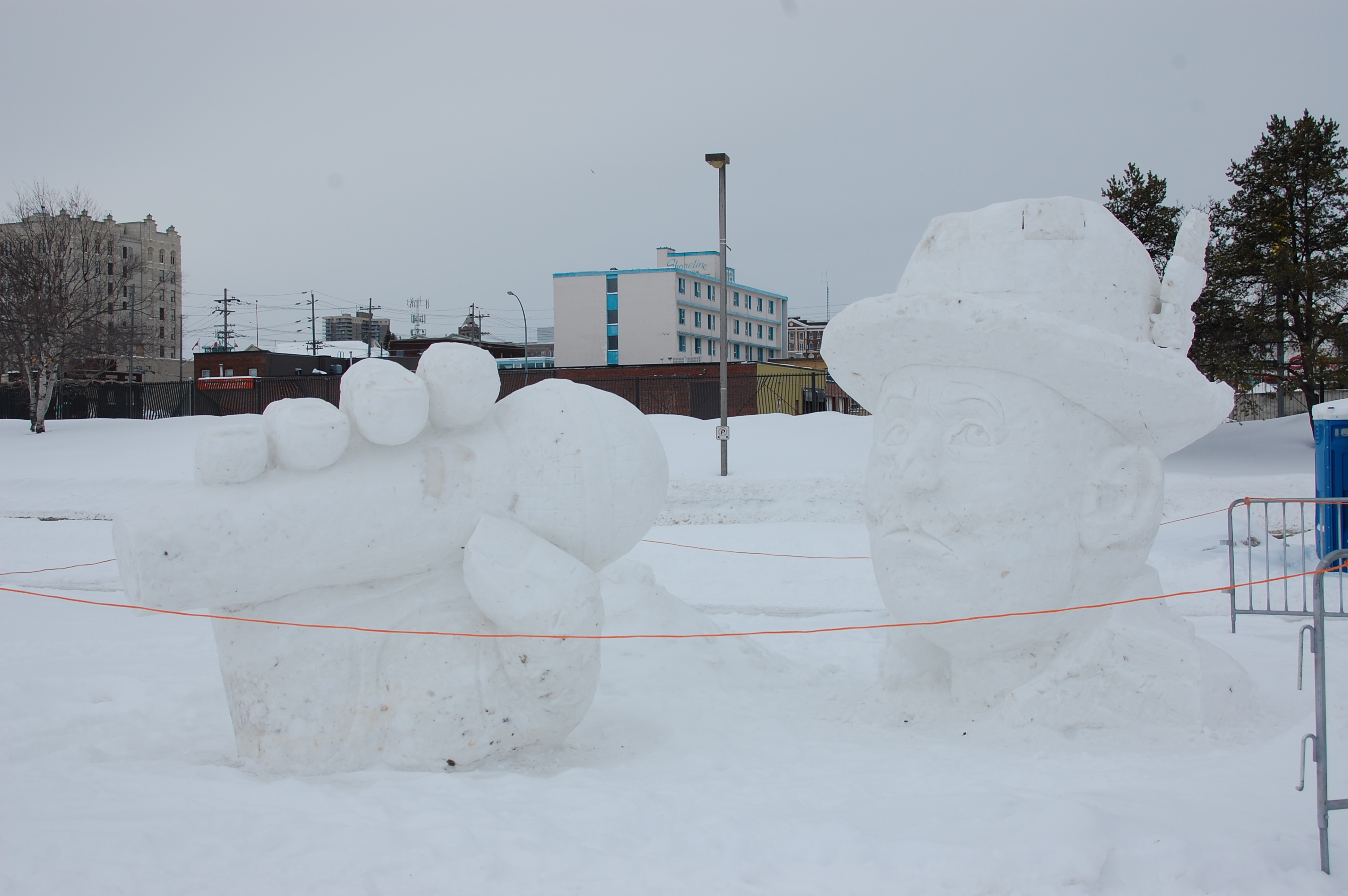 A snow sculpture of Gord Downie holding a big microphone