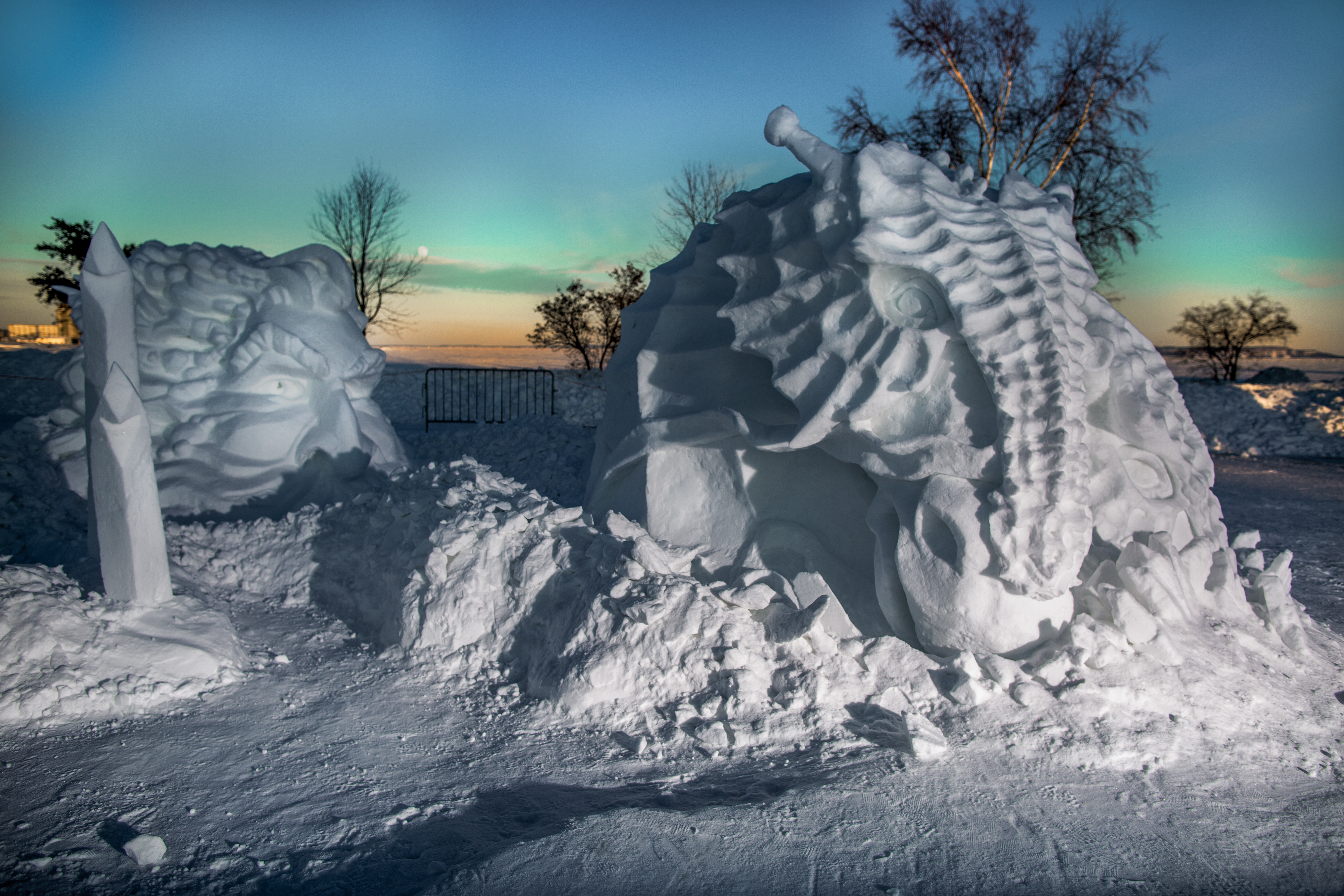 a snow sculpture of a dinosaur and the mythical figure of Poseidon 