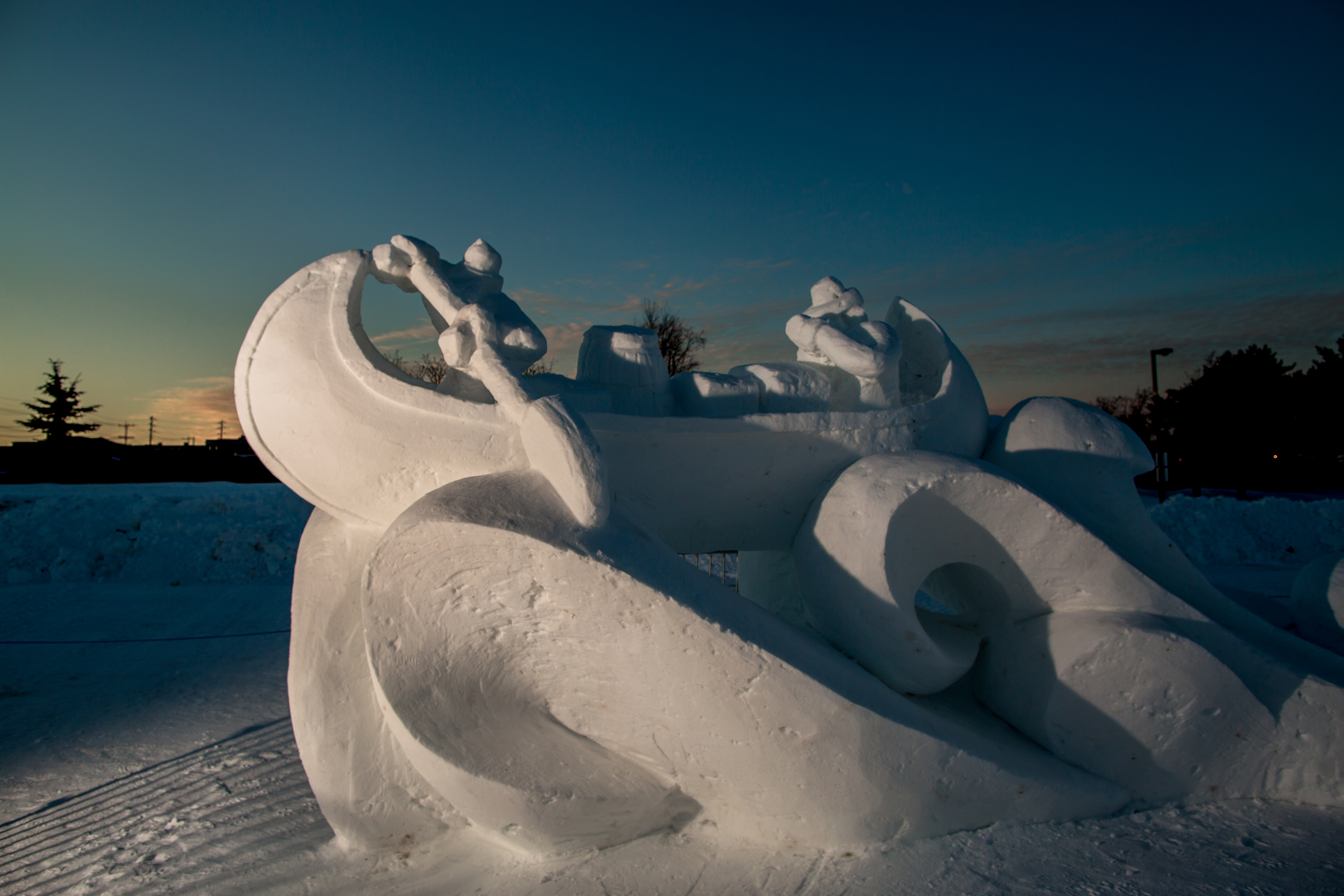 A snow sculpture of a canoe traversing the water