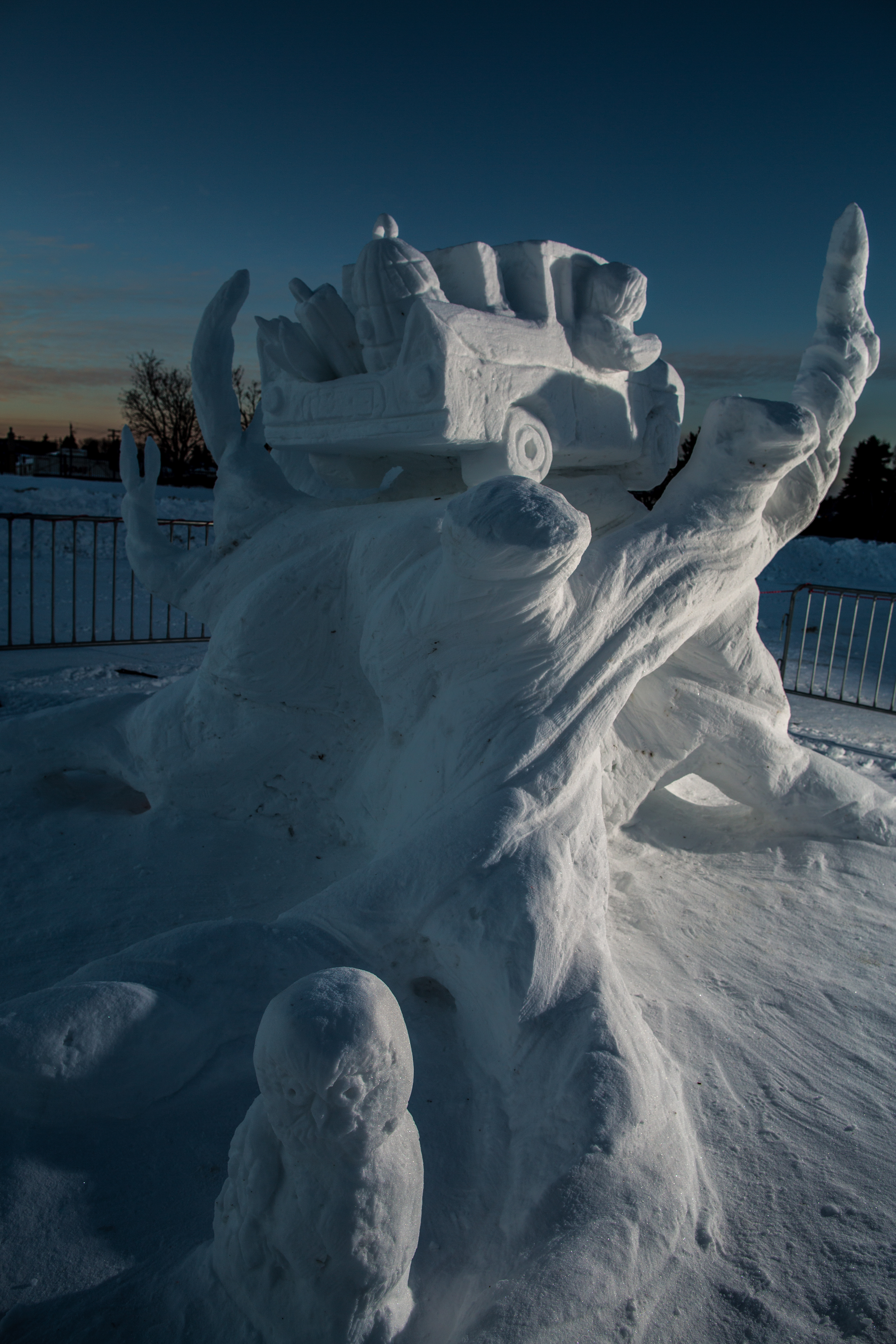 A snow sculpture of the fictional whomping willow tree from harry potter holding a car