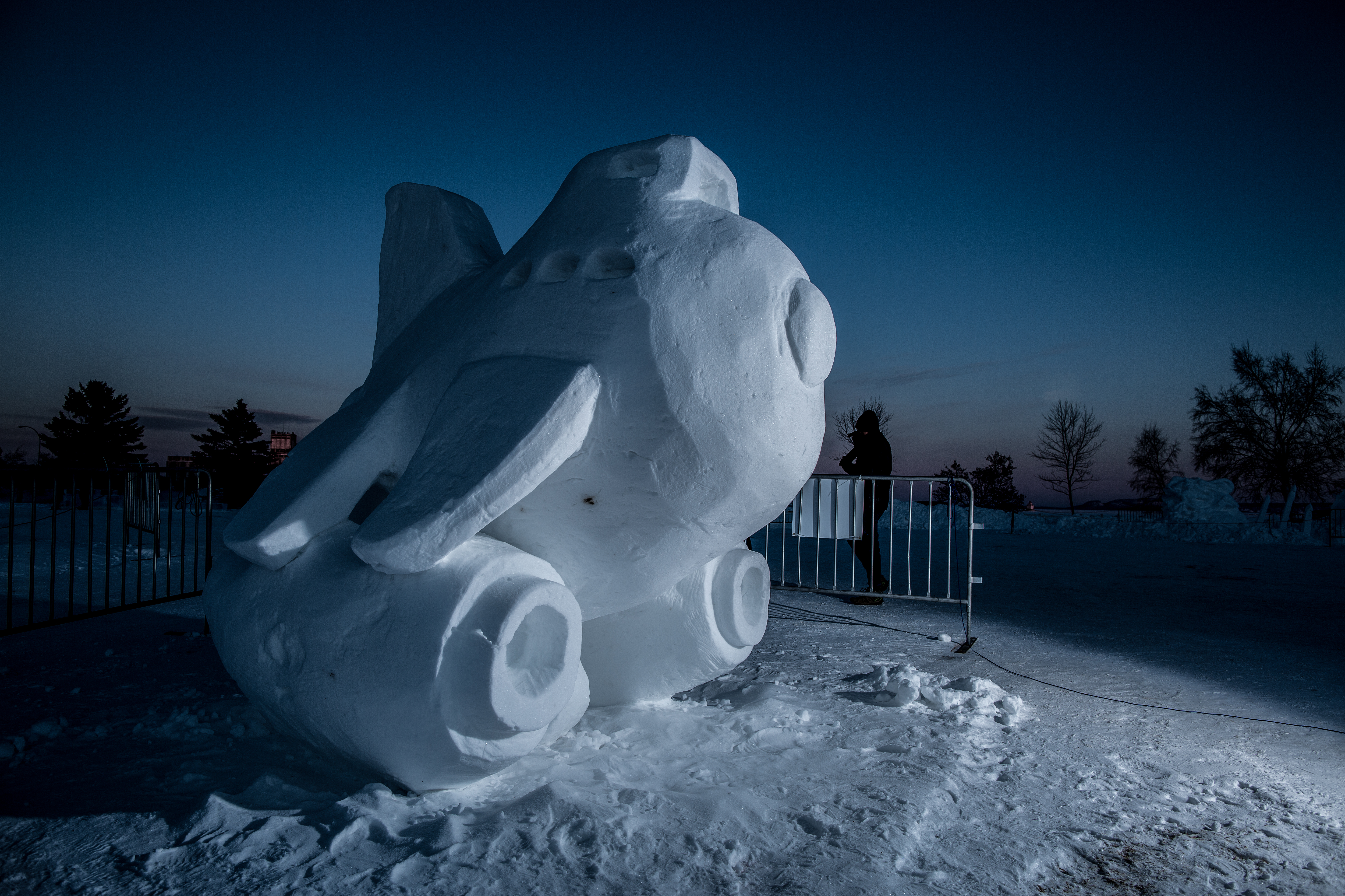 A snow sculpture of an airplane flying in the sky with a Disney logo
