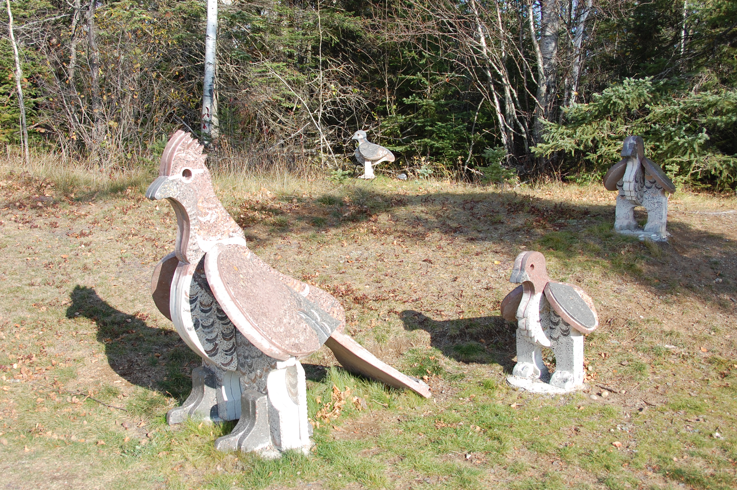 A stone sculpture series of a mother partridge and her chicks