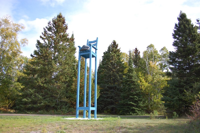 An installation of a large beach chair with a hat on the seat
