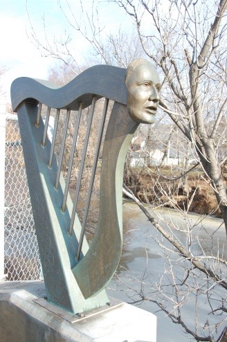 A photo of a bust of Catherin Vickers attached to a harp