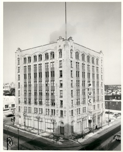 A tall building with multiple windows sitting alone on a city street