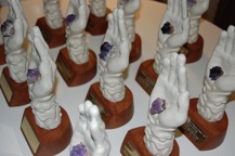 various porcelain hand sculptures holding purple jewels