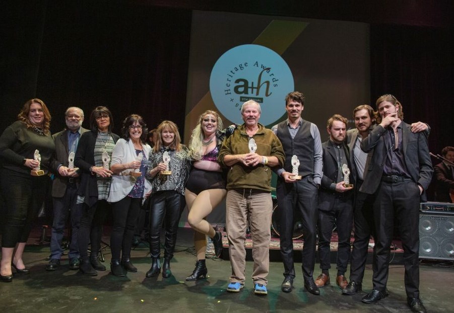 group of award winners standing on a stage