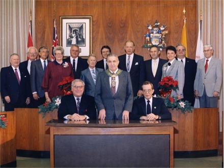 The 1988 City Council of Thunder Bay stand and sit together in an official portrait with the mayor in the centre
