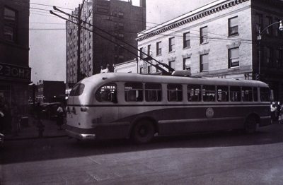 a trolley with its wig wags extended going down the street