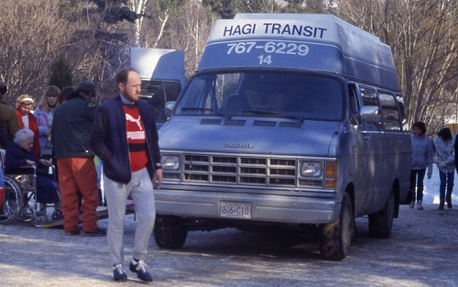 A person standing in front of a blue and white Handi-Transit van