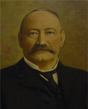 Mayor Conmee sits wearing a black suit and has a large moustache