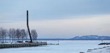 a tall sculpture by the water
