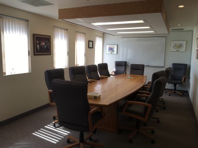 inside of the 55 Plus Centre Board Room with large desk and chairs'