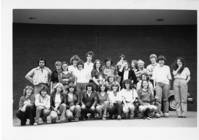 A group of people stand in a black and white photo